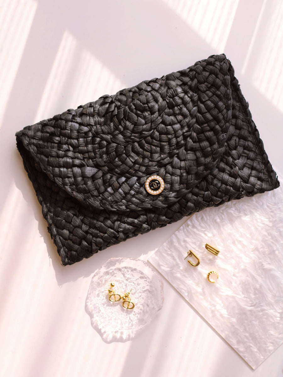 "THE CLUTCH" BLACK FOLD-OVER STRAW BAG by RAËLIV